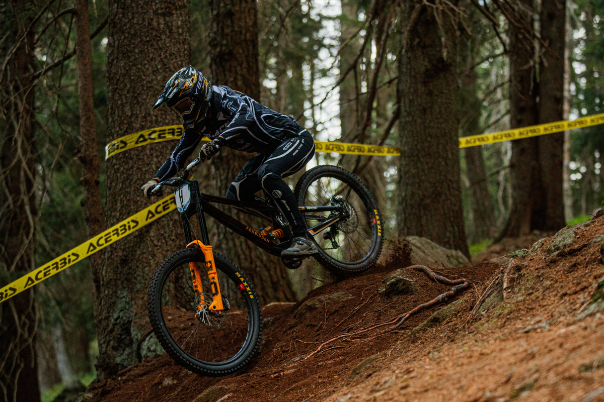 Rider Black Crew in discesa nel bosco con mountain bike